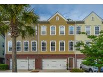 Charming townhome with colorful facade, two-car garage, and palm tree in the landscaped front yard at 3517 Claremont St, Mount Pleasant, SC 29466