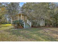 Charming home featuring a quaint porch, lush trees, and a well-manicured lawn at 4401 Prices Bridge Ln, Walterboro, SC 29488