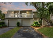 Inviting two-story condo with a private balcony, garage, and lush landscaping at 55 Fairway Dunes Ln, Isle of Palms, SC 29451