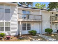 Charming two-story townhome featuring a balcony and a well-maintained front yard with a sidewalk leading to the front door at 7838 Nummie Ct, North Charleston, SC 29418