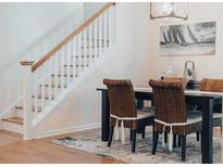 The dining room has a staircase, a dark wood table and four wicker chairs at 7850 Wilderness Trl # 6A, North Charleston, SC 29418