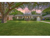 Charming brick home with a lush green lawn and mature tree in a peaceful neighborhood setting at 816 Farnham Rd, Charleston, SC 29412