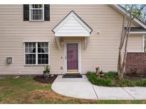 Inviting home entrance featuring a covered front door, neutral siding, and charming landscaping at 8651 Grassy Oaks Trl, North Charleston, SC 29420