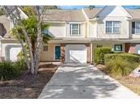 Charming townhome featuring a one car garage, a blue front door and mature trees at 8653 Grassy Oak Trl, North Charleston, SC 29420
