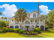 Charming two-story home with lush landscaping, a welcoming front porch, and classic architectural details at 1 Bay Ct, Isle of Palms, SC 29451