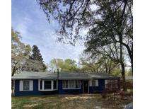 Charming blue home with white trim, manicured lawn, and mature trees at 1018 Bradford Ave, Charleston, SC 29412