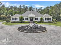 Beautiful single-story home with a circular driveway and manicured landscaping on a lush green lot at 1019 Spiers Cir, Bonneau, SC 29431