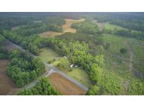 Sprawling property featuring a home surrounded by lush greenery and fields viewed from above at 1050 Mt Zion Rd, Saint George, SC 29477