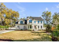 Charming two-story home featuring a well-manicured lawn, mature trees, and a classic American architectural style at 1081 Groves Manor Ct, Mount Pleasant, SC 29464