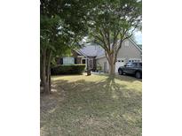 Charming single-Gathering home featuring a manicured lawn, brick accents, and an attached two-car garage at 1317 Wild Olive Dr, Mount Pleasant, SC 29464