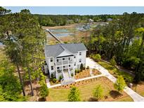 Stunning waterfront home featuring a private pier, lush landscaping, and a classic two-story design at 2372 Darts Cove Way, Mount Pleasant, SC 29466