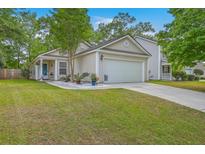 Charming single-story home with a well-manicured lawn, attached garage, and beautiful landscaping at 2427 Stingray Blvd, North Charleston, SC 29406