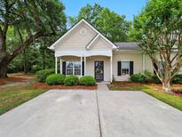 Charming single-story home with a cozy front porch and well-manicured landscaping at 325 Dupont Way, Summerville, SC 29485