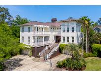 Stunning multi-story home boasts a white exterior, multi-level balconies, and a meticulously landscaped front yard at 337 Evian Way, Mount Pleasant, SC 29464