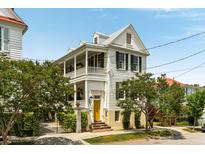 Charming two-story home with double porches, yellow front door, and mature landscaping at 6 Judith St, Charleston, SC 29403