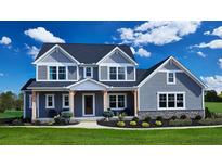 Charming two-story home featuring board and batten siding, large front porch, and manicured landscaping at 100 Fish Rd, Ridgeville, SC 29472