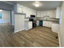 Bright kitchen features white cabinets, granite countertops and new flooring at 1070 French Quarter Creek Rd, Huger, SC 29450