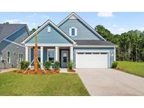 Charming single-story home featuring a two-car garage, blue siding, and a well-manicured front lawn at 139 Summerwind Dr, Summerville, SC 29486