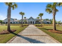 Beautiful community clubhouse with manicured lawn, walkway and palm trees on a sunny day at 141 Trillium Cir, Summerville, SC 29486