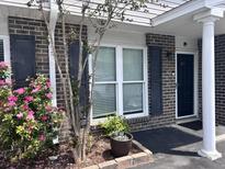 Charming brick townhome with dark shutters and blooming roses at 1735 Boone Hall Dr # K6, Charleston, SC 29407