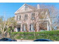 Elegant Charleston home with a pink facade, wrought iron fence, and beautiful architectural details at 192 Ashley Ave # C, Charleston, SC 29403