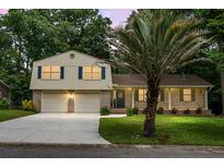 Charming two-story home with a well-manicured lawn, brick facade, and a two-car garage at 211 Bramblewood Dr, Summerville, SC 29485