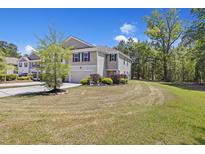 Charming two-story home with a two car garage, manicured landscaping, and a private wooded backyard at 254 Cypress Marsh Rd, Moncks Corner, SC 29461