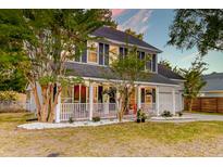 Charming home featuring a cozy front porch, mature trees, and a well-manicured lawn at 3298 Heathland Way, Mount Pleasant, SC 29466