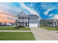 Charming two-story home featuring a welcoming porch, well-manicured lawn, and a two-car garage at 424 Carrara Dr, Summerville, SC 29486