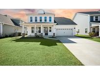 Charming two-story home featuring manicured lawn, two-car garage, and inviting front porch at 490 Rowley Ln, Summerville, SC 29486