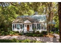 Charming cottage-style home with a lush, tree-lined yard and cozy front porch at 622 Venning St, McClellanville, SC 29458