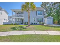 Charming two-story home with double porches, attached garage, and a well-manicured lawn at 7401 Purser Ln, Hanahan, SC 29410