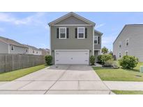 Two-story home featuring a two-car garage, neutral siding, and well-maintained landscaping at 9706 Fanning Basket Ln, Ladson, SC 29456