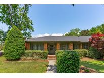 Charming one-story brick home featuring a lush front yard with manicured landscaping at 1 Marlow Dr, Charleston, SC 29403