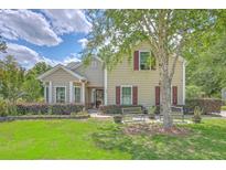 Charming home with manicured lawn, benches, and mature landscaping offering pleasant curb appeal at 105 Irish Oak Dr, Goose Creek, SC 29445