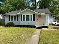 Charming single-story home with light gray siding, black shutters, and a vibrant pink front door at 1159 Camden St, North Charleston, SC 29405