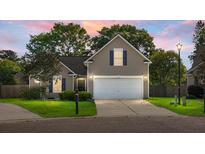 Charming single-Gathering home with a well-manicured lawn and two-car garage at dusk at 129 Mockernut Dr, Ladson, SC 29456