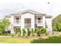 Inviting two-story condo with double balconies, lush landscaping, and a well-maintained lawn at 1300 Park West Blvd # 919, Mount Pleasant, SC 29466