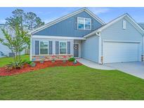 Charming home featuring a two-car garage, a welcoming front yard, and stone accents near the house's entrance at 137 Clydesdale Cir, Summerville, SC 29486