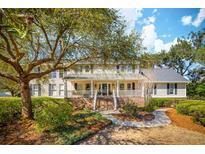 Charming two-story home with a welcoming front porch, mature trees, and landscaped front yard at 1511 Fairway Dr, Charleston, SC 29412