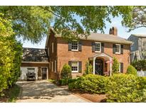 Charming two-story red brick home with black shutters, landscaped yard, and a detached garage at 2 Pierates Cruz, Mount Pleasant, SC 29464