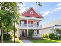 Charming two-story home with double porches, a red facade, and a professionally landscaped front yard at 218 Barberry St, Summerville, SC 29483