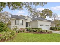 Charming single-story home featuring a well-manicured lawn and lush landscaping with a two-car garage at 2525 Bent Tree Ln, Mount Pleasant, SC 29464