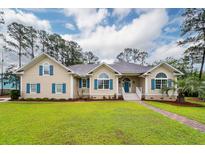 Charming one-story home featuring a spacious front yard with lush green grass and a brick walkway at 287 Commonwealth Rd, Mount Pleasant, SC 29466