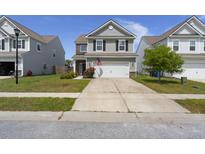 Charming two-story home with a two car garage, manicured lawn and flower beds at 5222 American Holly Ln, Ladson, SC 29456