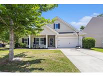 Charming home with manicured lawn, a two-car garage, and a welcoming front porch with rocking chair at 5400 Turning Tide, North Charleston, SC 29420