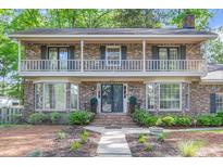 Charming brick home featuring a lovely front yard, covered porch and beautiful second-story balcony at 615 Fairington Dr, Summerville, SC 29485