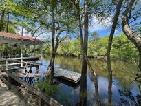 Scenic river view featuring a gazebo and dock surrounded by lush trees at 78 Hannibal Trl, Ridgeville, SC 29472