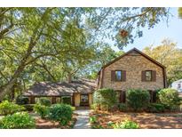 Charming brick home with mature trees and manicured landscaping creates a welcoming curb appeal at 810 Creekside Dr, Mount Pleasant, SC 29464