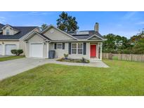 Charming single-story home with vinyl siding, attached garage, well-kept lawn, and a vibrant red front door at 8524 Brookforest Dr, Charleston, SC 29406